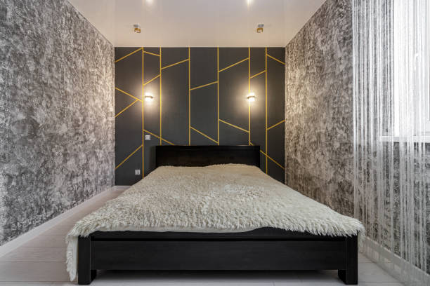 Modern bedroom space with grey walls and a large bed.