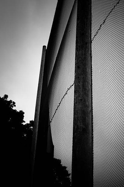 Tall golf fence in black and white stock photo