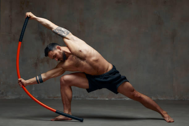 istock A ninja man holds on to a fighting stick and attacks close-up on gray studio background 1864215639