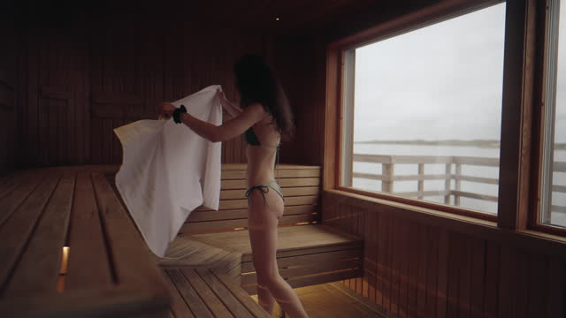 Woman sitting down on a bench in the sauna