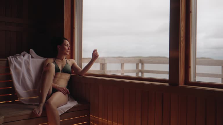 Woman sitting in the sauna, day dreaming