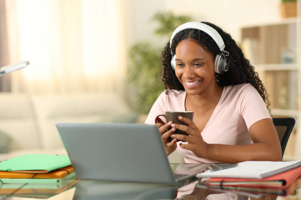 istock Happy black woman e-learning drinking at home 1864243696