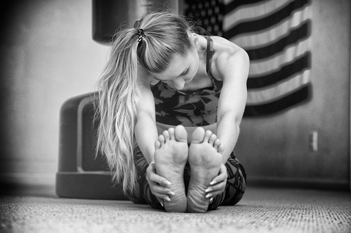 Martial artist stretching in her home gym.