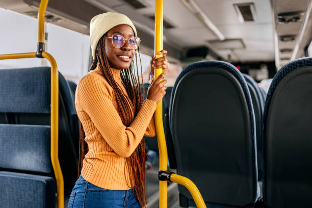 young smiling beautiful woman riding in a public bus - bus riding public transportation businessman imagens e fotografias de stock