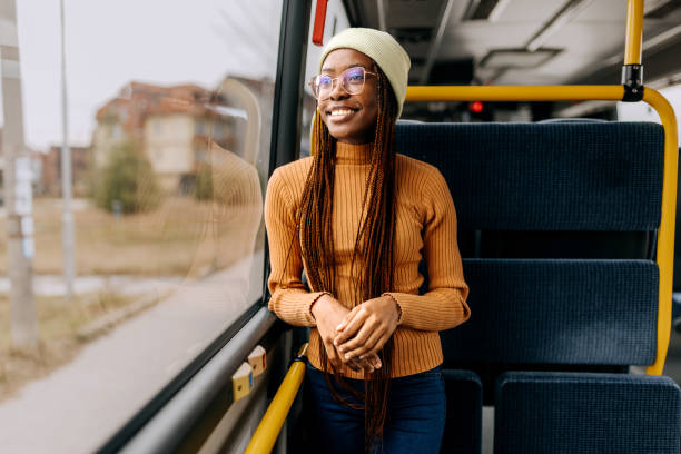 young smiling beautiful woman riding in a public bus - bus riding public transportation businessman imagens e fotografias de stock