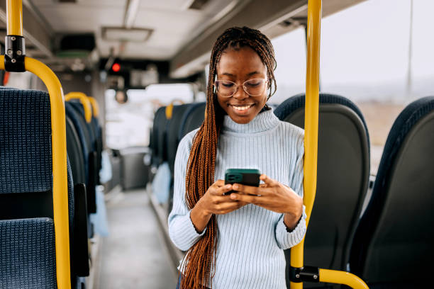 istock Young smiling casually clothed woman using smart phone while riding in a public bus 1864272327