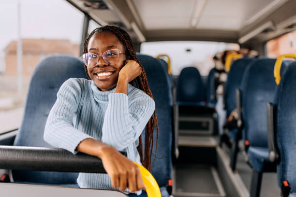 young smiling beautiful woman riding in a public bus - bus riding public transportation businessman imagens e fotografias de stock