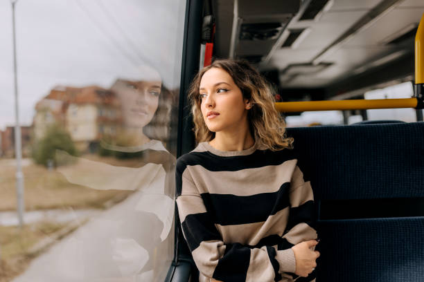 young smiling beautiful woman riding in a public bus - bus riding public transportation businessman imagens e fotografias de stock