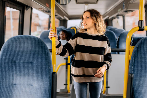 young smiling beautiful woman riding in a public bus - bus riding public transportation businessman imagens e fotografias de stock