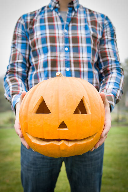 Man holds Halloween pumpkin stock photo