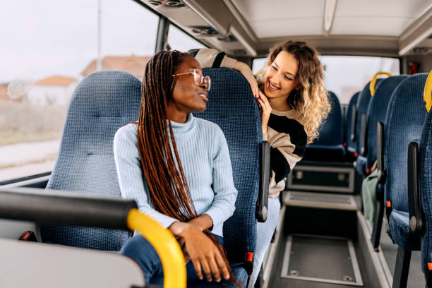 istock Two female friends talking while riding in a public bus 1864272854