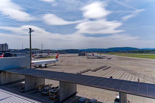 Wide angle view of parked Swiss airplanes at Zürich Kloten Airport on a sunny summer day. Photo taken July 23rd, 2023, Zurich, Switzerland.