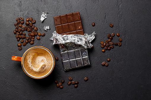 Coffee break bliss: Chocolate bar paired with a cup of coffee. Flat lay with copy space