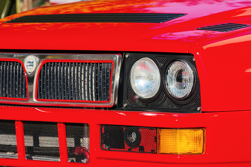 uzhgorod, ukraine - 31 oct 2021: close-up of a red lancia delta. grille, headlights and hoood of a legendary italian rally car