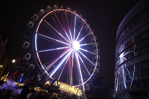 Wiesbaden, Germany, December 17, 2023, The Ferris wheel in the Christmas Market in Wiesbaden city and the visitors of the market are everywhere around.