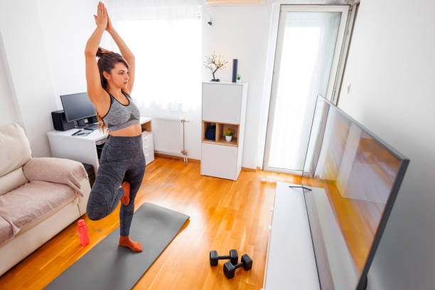 istock Active woman doing online yoga session at home 1864383577