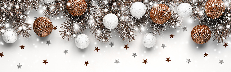 Christmas white background with fir branches, white and brown balls. New year card. Copy space. Banner. Demonstrating color of 2024 year - peach.