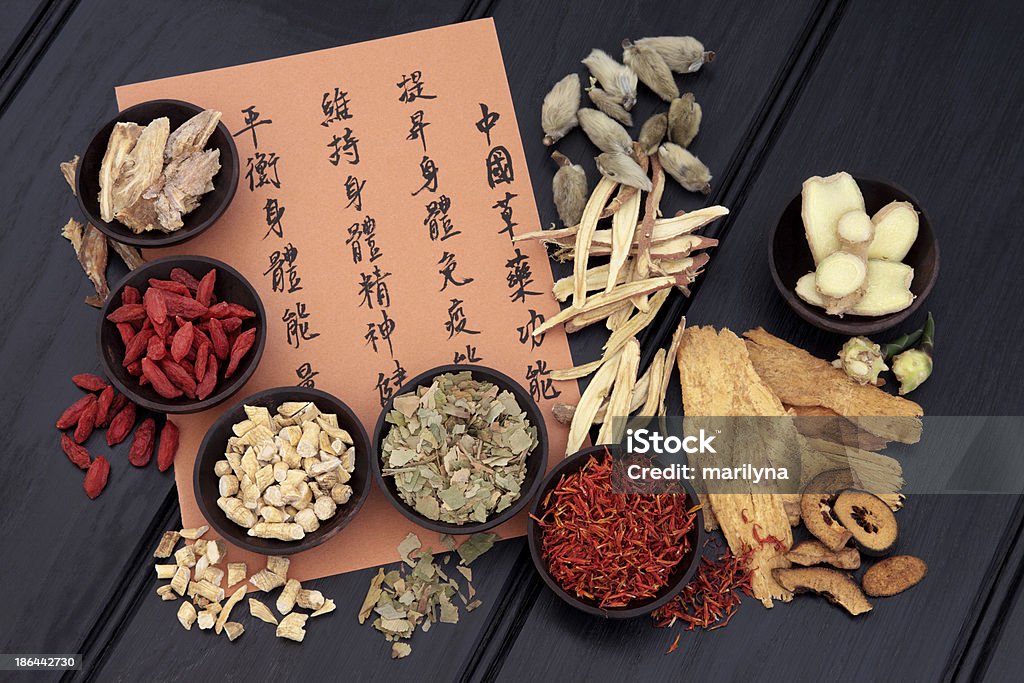 Healthy Lifestyle Traditional chinese herbal medicine selection with mandarin calligraphy. Translation describes the medicinal functions to increase the bodys ability to maintain body and spirit health and balance energy. Alternative Medicine Stock Photo