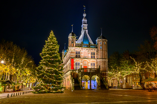 Deventer winter evening street view at the Brink square with the old Waag building and  Christmas decorations in the old town famous for the annual Dickens festival in the days before Christmas.