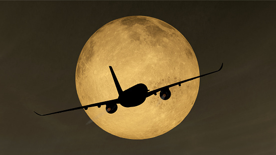 Night flight - Plane takes off at night before full moon