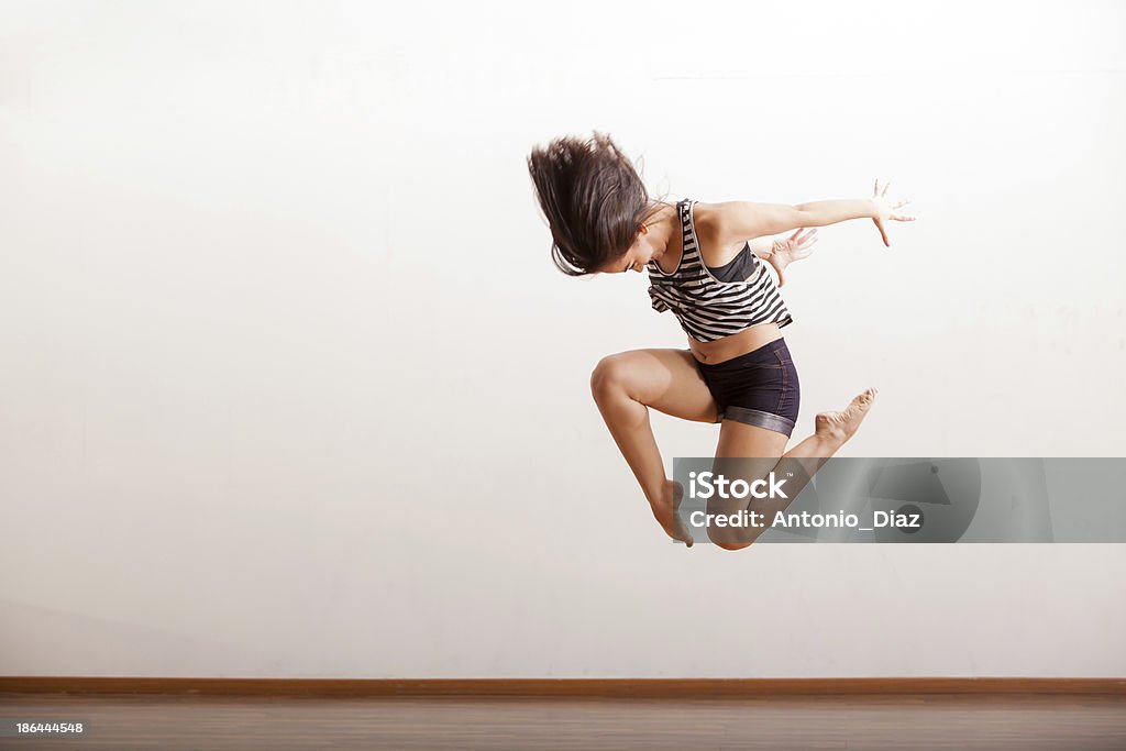 Jazz dancer performing a jump Female jazz dancer in the middle of a jump as part of a dance routine Jazz Music Stock Photo