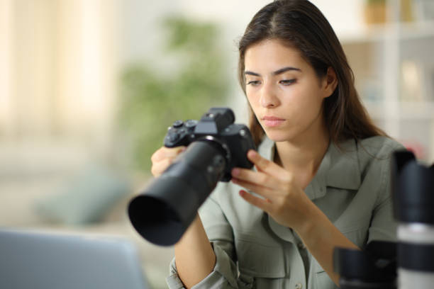 istock Serious photographer checking camera at home 1864457556
