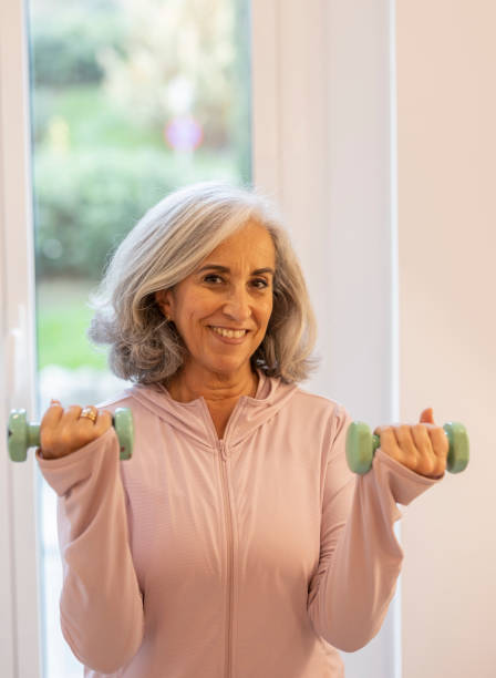 istock portrait retired senior woman looking at camera while practicing rehabilitation exercises with her dumbbells 1864468666