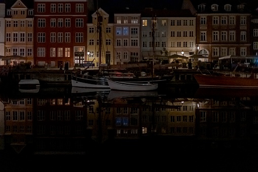 Reflektion von häusern und booten bei nacht in nyhavn