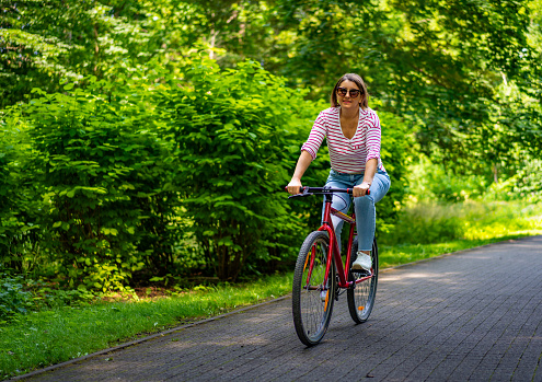 Urban biking - woman riding bike in city park