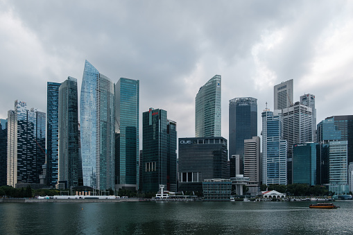 A dynamic city scene featuring skyscrapers, businesses, and offices along the Singapore River, capturing the essence of urban life and modern architecture.