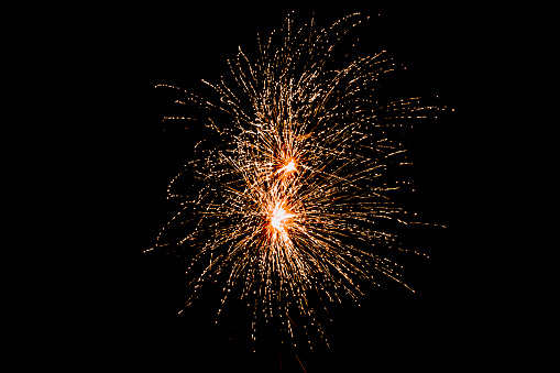 A stunning orange reddish firework bursts in the dark black skies, adding a touch of magic to your celebration visuals. Perfect for festive projects and memorable occasions.