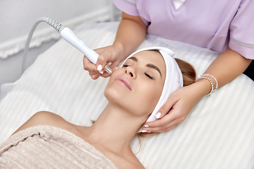 beautiful woman getting microdermabrasion procedure in a beauty spa salon