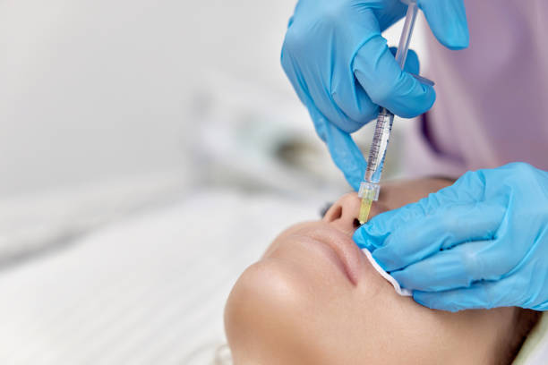istock cosmetologist makes injections to enlarge the lips 1864508679