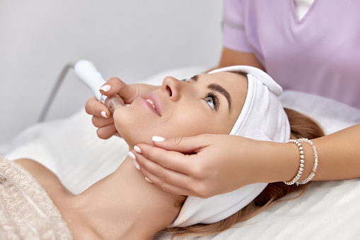 beautiful woman getting microdermabrasion procedure in a beauty spa salon