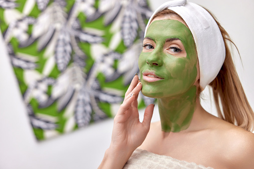 beautiful woman with green alginate mask on face