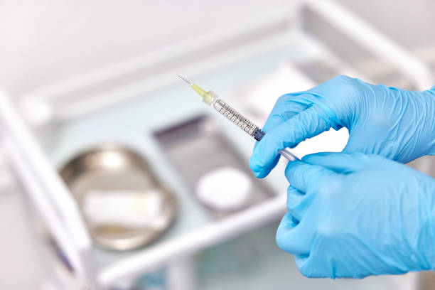 istock Physician hand in blue gloves with syringe 1864509315