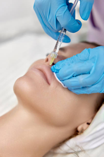 istock cosmetologist makes injections to enlarge the lips 1864509358