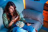 Woman using smart phone and watching TV at home
