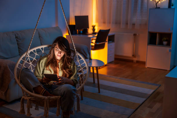 istock Woman relaxing at home reading an ebook 1864514693