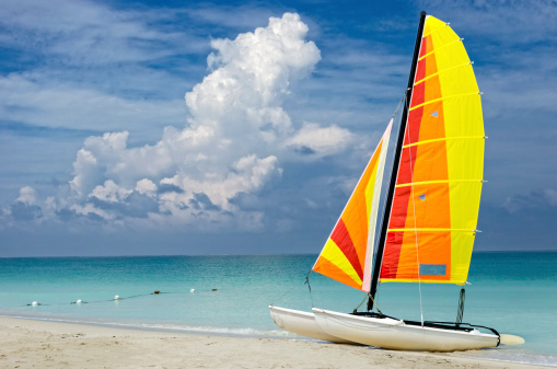 A catamaran is left unused on a Caribbean beach as a storm approaches.