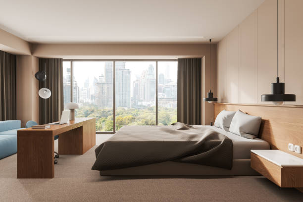 istock Stylish home bedroom interior with workplace, bed and sofa near window 1864549716