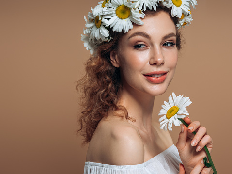 Young beautiful girl with beautiful flowers on her head