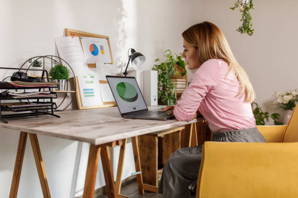 istock Woman sitting at home office desk, using laptop 1864571459