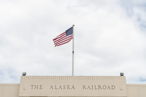 Anchorage Railway depot sign with a Stars and Stripes flag, Anchorage, Alaska, USA