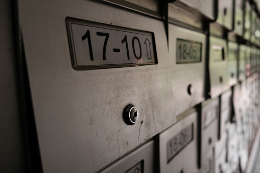 A close-up shot of a vintage and old letterbox unit number, with the surrounding letterboxes blurred in the background, showcasing the nostalgic charm of a bygone era, requiring a key for access.
