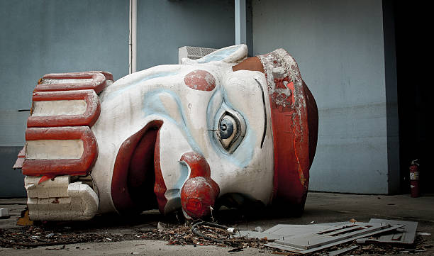 Scary abandoned clown head Stylized image of a fallen clown head in an abandoned new orleans theme park.  Smashed and scatters amongst Katrina rubble.  this image was taken in late 2011 and is under no copyright abandoned stock pictures, royalty-free photos & images