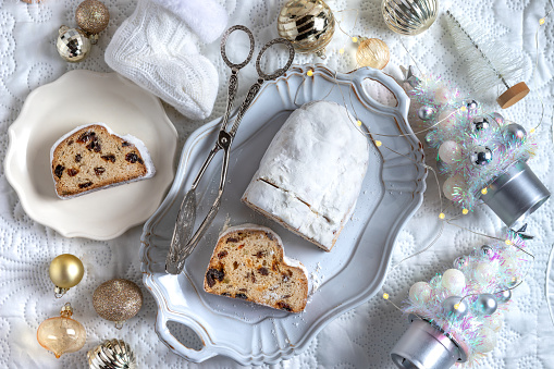 Christmas stollen. Traditional german Christmas dessert and Christmas ornaments on white festive background