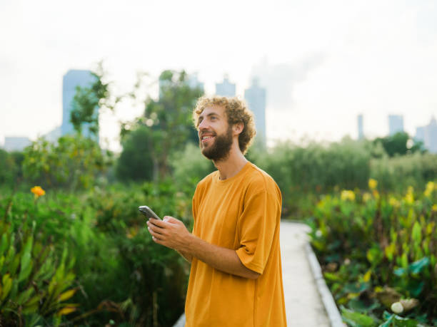istock Man on morning walk through lush foliage in downtown 1864609297