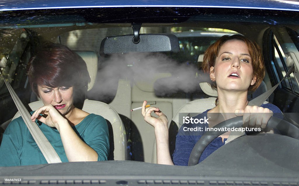 Segunda mano humo de un conductor en un coche para fumadores - Foto de stock de Tabaquismo pasivo libre de derechos