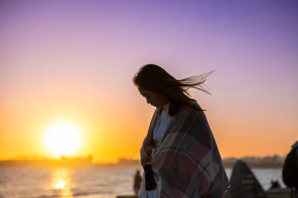 Woman standing on beach at sunset time